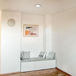 Pasillo con banco iluminado con empotrable Know gris de 12 watios