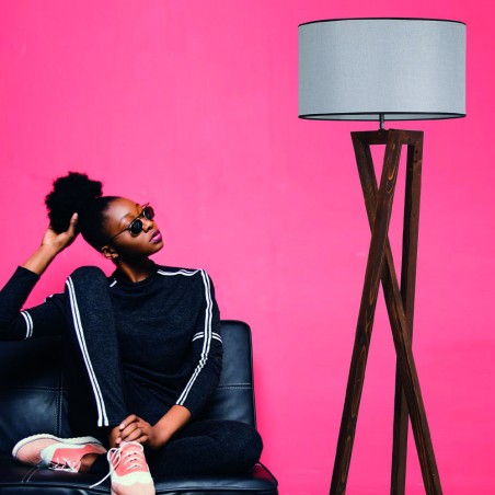 jovén sentada en un sofa junto a Lámpara de pie de madera Model 4 gris