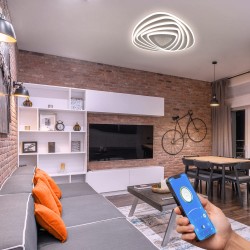 Salón decorado con el Plafón Smart Mei 3D 115W 3CCT regulable encendido con luz neutra y controlado des un teléfono móvil