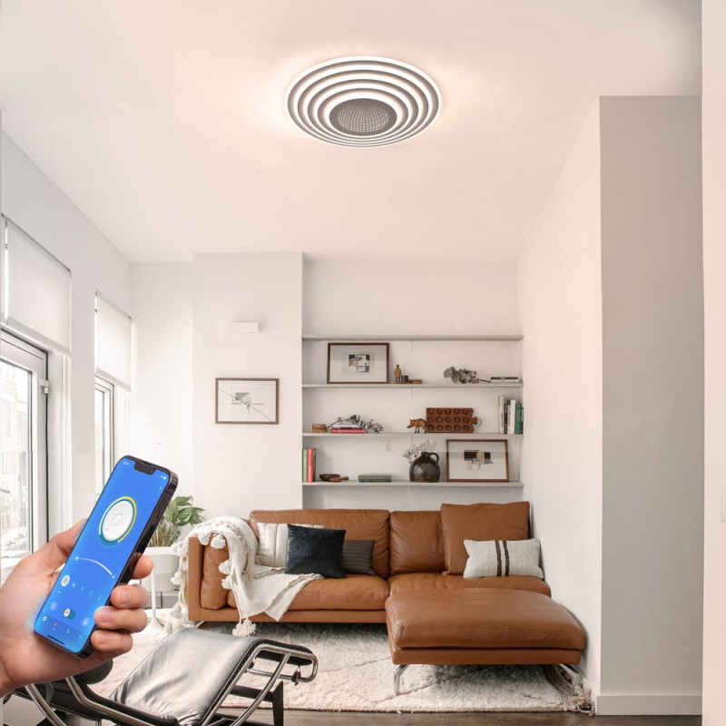 Salón decorado con el Plafón Smart Mei 3D 125W 3CCT regulable endendido con luz neutra controlado desde el teléfono móvil