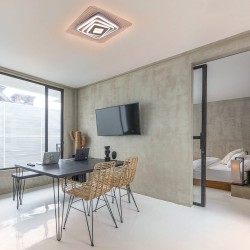 Oficina moderna decorada con el Plafón Smart Ara 70W 3CCT regulable encendido con iluminación combinada en tono de luz cálida