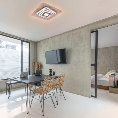 Oficina moderna decorada con el Plafón Smart Ara 70W 3CCT regulable encendido con iluminación combinada en tono de luz cálida
